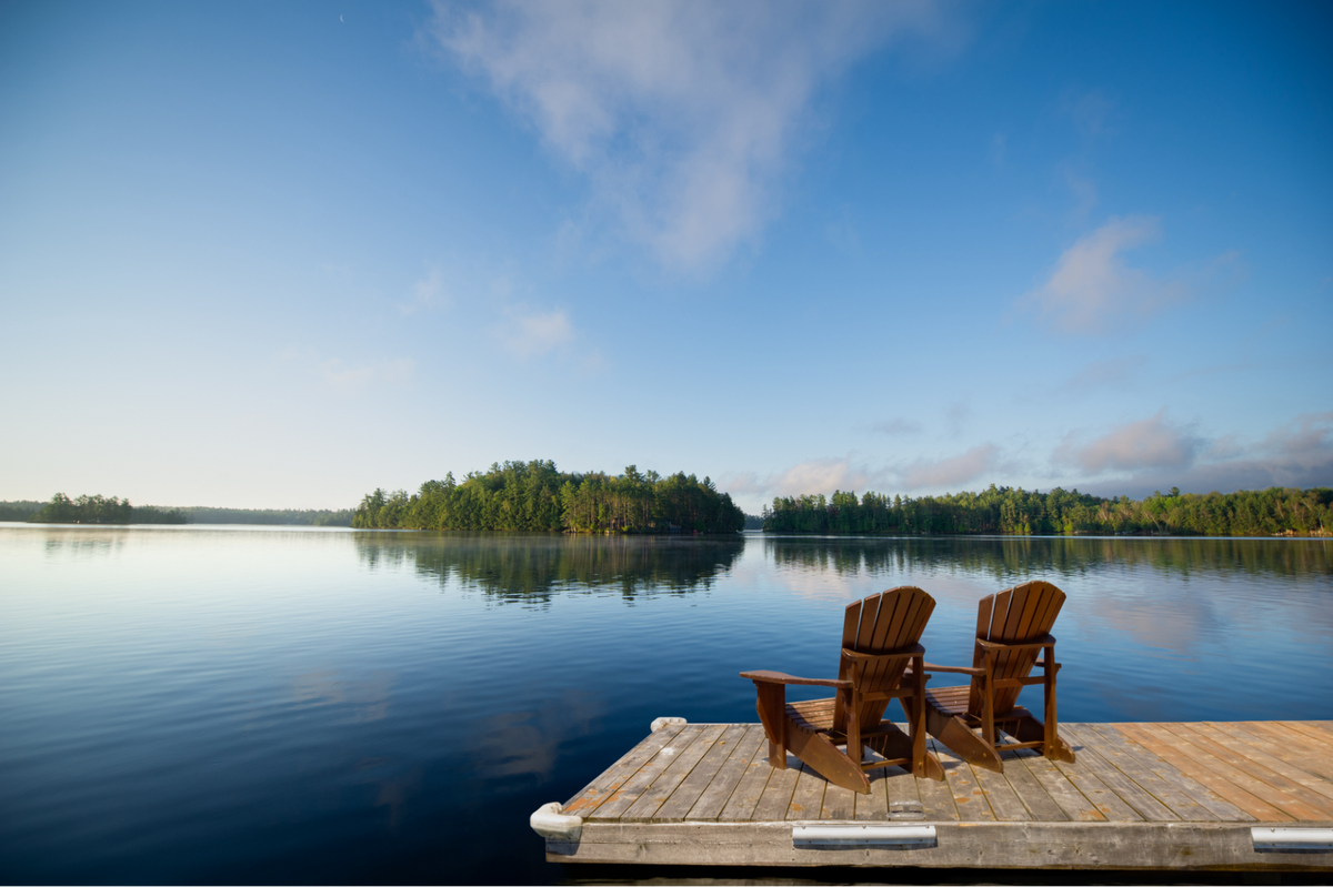 View of lake with two chairs on the dock