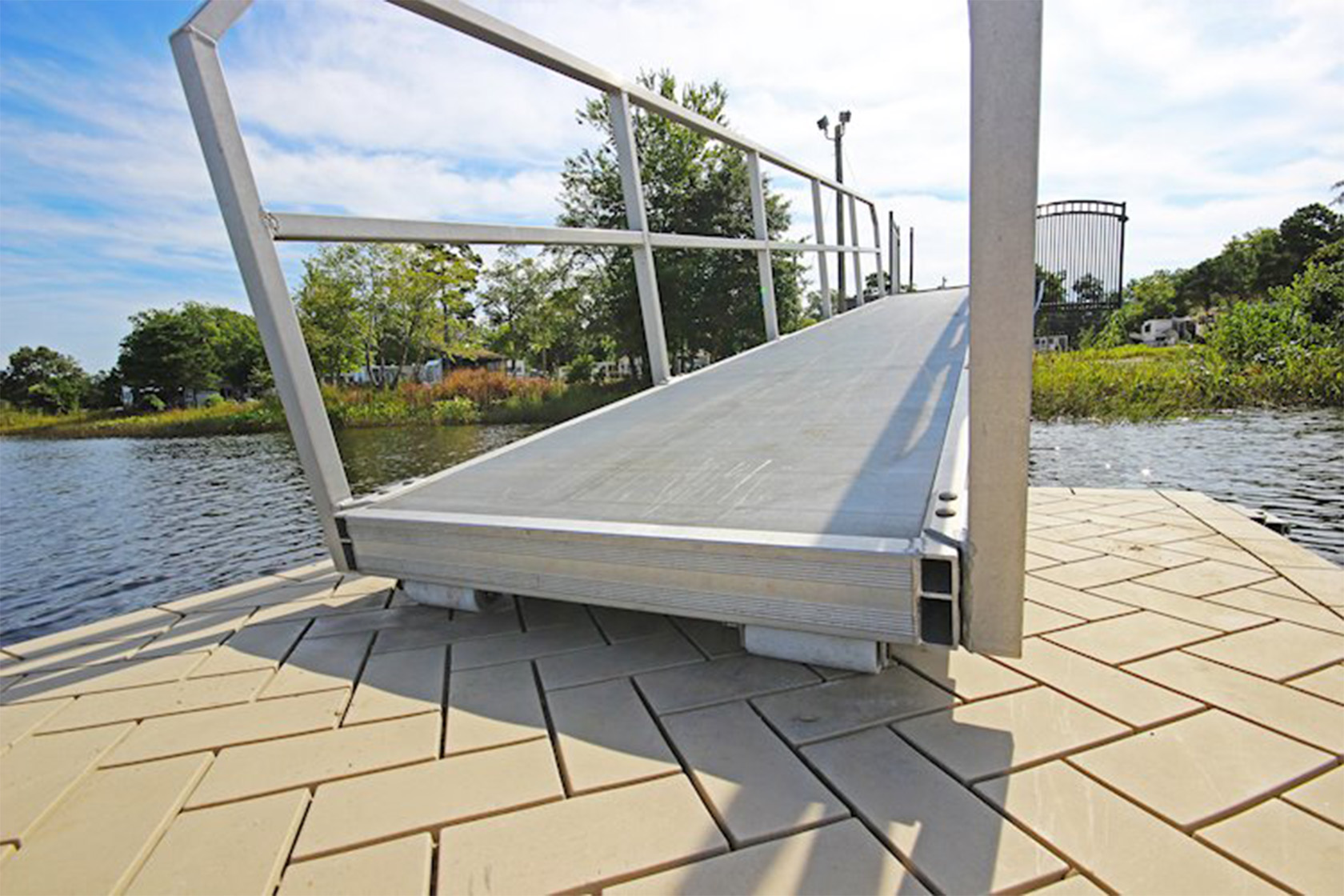 Aluminum dock ramp connected to a floating dock on a peaceful lake.